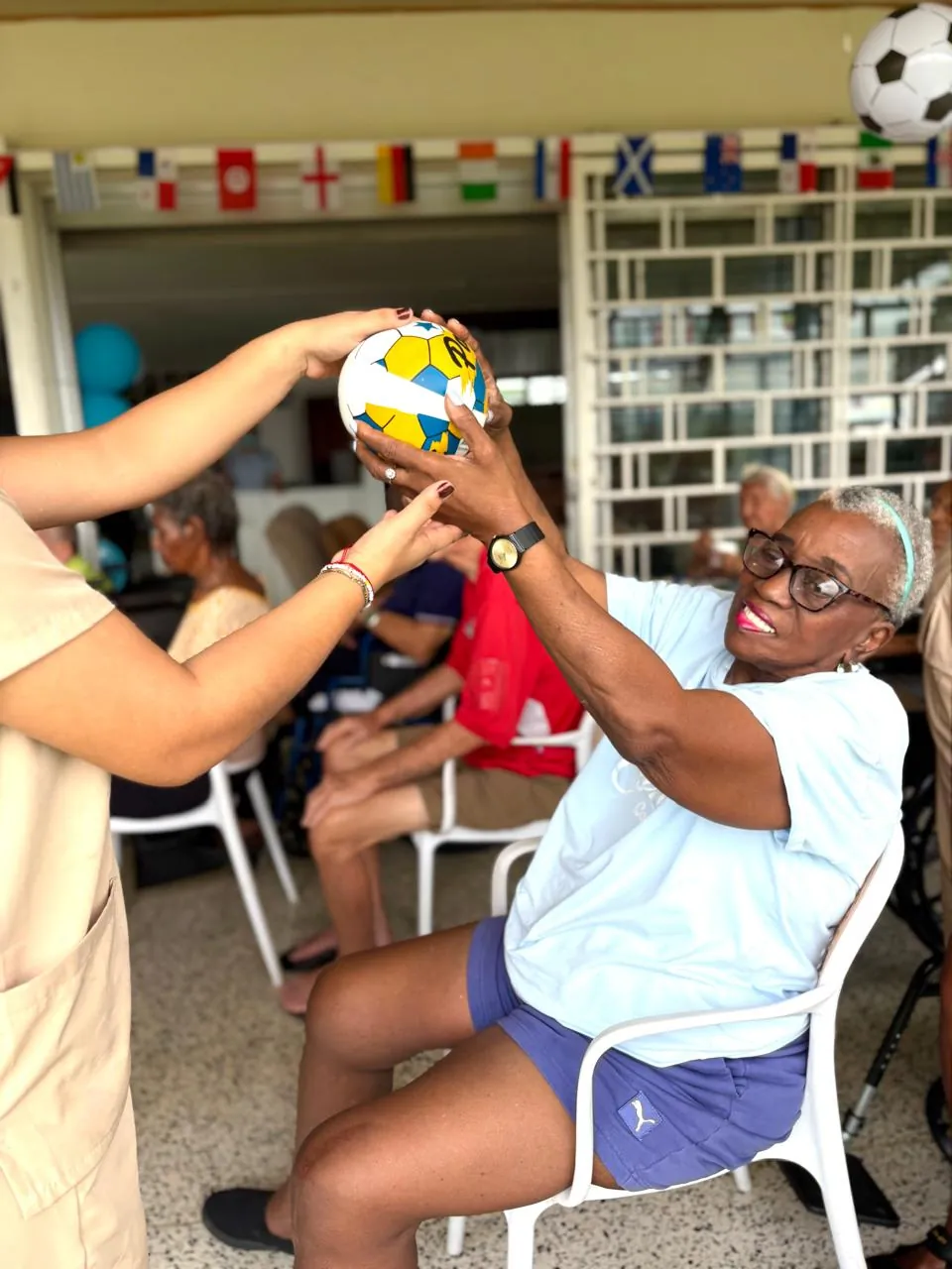 Juego con pelota entre residentes y cuidadora